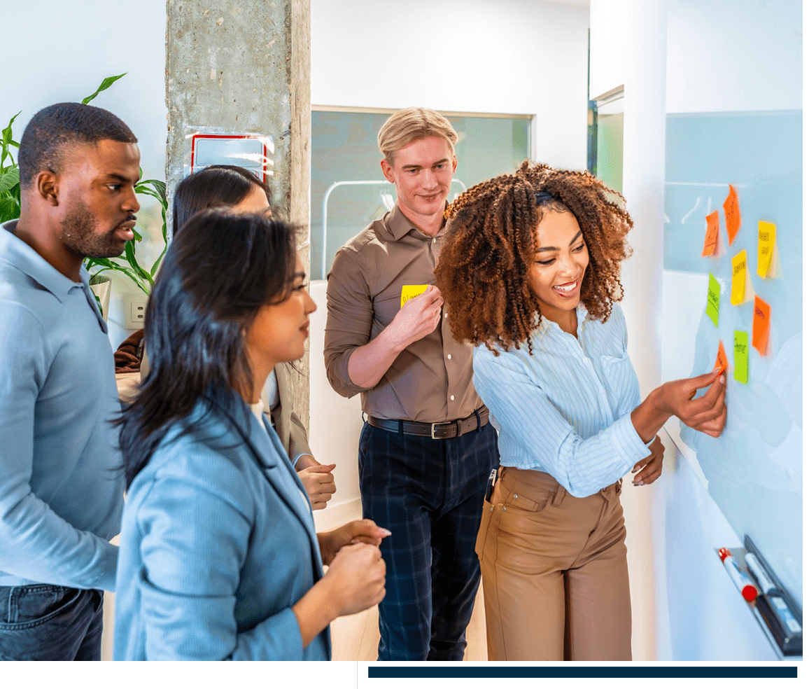 Team brainstorming with sticky notes on board.